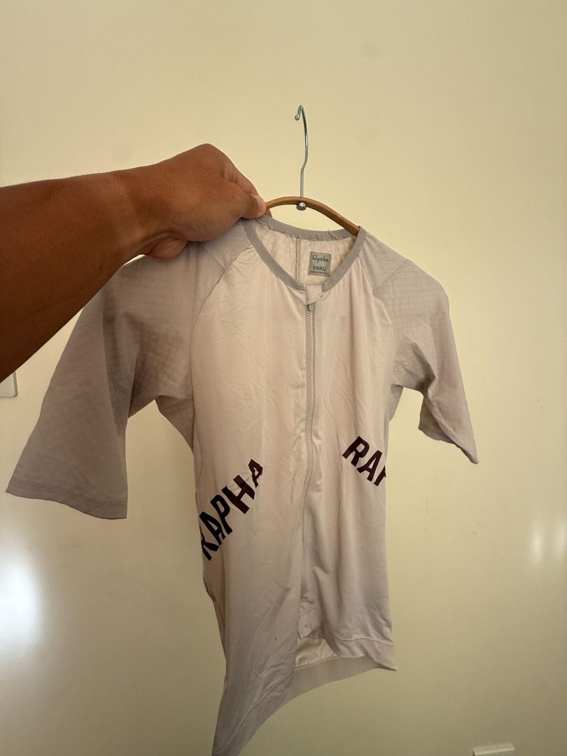 Rapha Cycling Aero Jersey (2) Small Black and Beige (Category: Activewear) located in Las Pinas. Submitted by cali022020 (Listing ID 1470353194, Image 3). Description: - Brand: Rapha - Size: Small - Color: Dark black with bold front lettering - Origin: Made in Portugal - Material: Lightweight technical fabric with textured sleeves and back panels - Features: Zip-up front design 4000 for Two RFS: Decluttering.