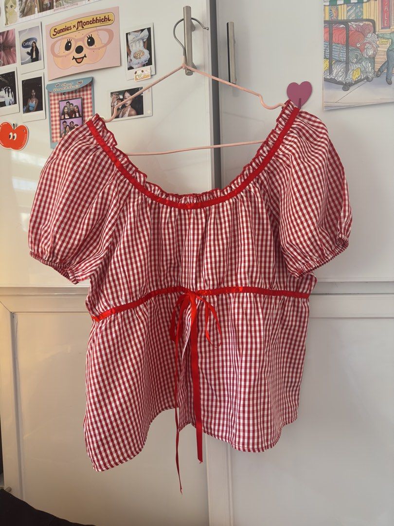 Red and White Gingham Blouse with Ribbon (Category: Blouses) located in Manila. Submitted by preloved-bycath (Listing ID 1470355548, Image 1). Description: - Style: Red and white check peasant top - Neckline: Square neck with ruffled trim - Sleeves: Short puffy sleeves with elastic cuffs - Details: Red ribbon tie under the bust - Fabric: Lightweight cotton, perfect for summer - Pairing: Easy to style with denim shorts or skirts.