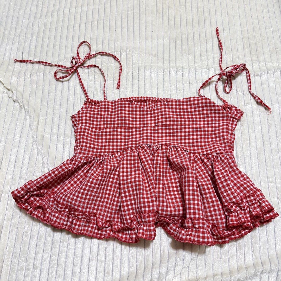 Red Gingham Peplum Top with Tie Straps (Category: Sleeveless) located in Manila. Submitted by ish.vintage (Listing ID 1470480672, Image 1). Description: - Red and white gingham cami top - Adjustable tie shoulder straps, sweet heart neckline and peplum flare hem with playful ruffled edge - Fabric: Lightweight and breathable cotton-blend - Perfect for: Summer days, beach trips, or casual lakwatsas - Styling tip: Best paired with denim shorts or hig