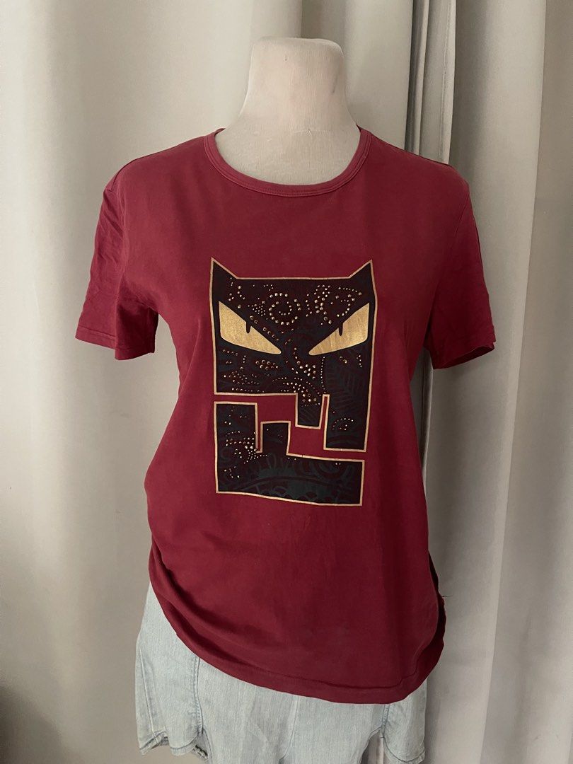 Red Graphic Tee with Gold Stud Details (Category: Shirts) located in Cainta. Submitted by zlove111 (Listing ID 1470455935, Image 1). Description: - Color: Maroon red - Style: Crew neck, short sleeves, regular fit - Material: Comfortable cotton jersey - Design: Abstract mask graphic with piercing yellow-gold eyes - Details: Decorated with metallic gold studs in swirl patterns small-large (slimfit 20") .