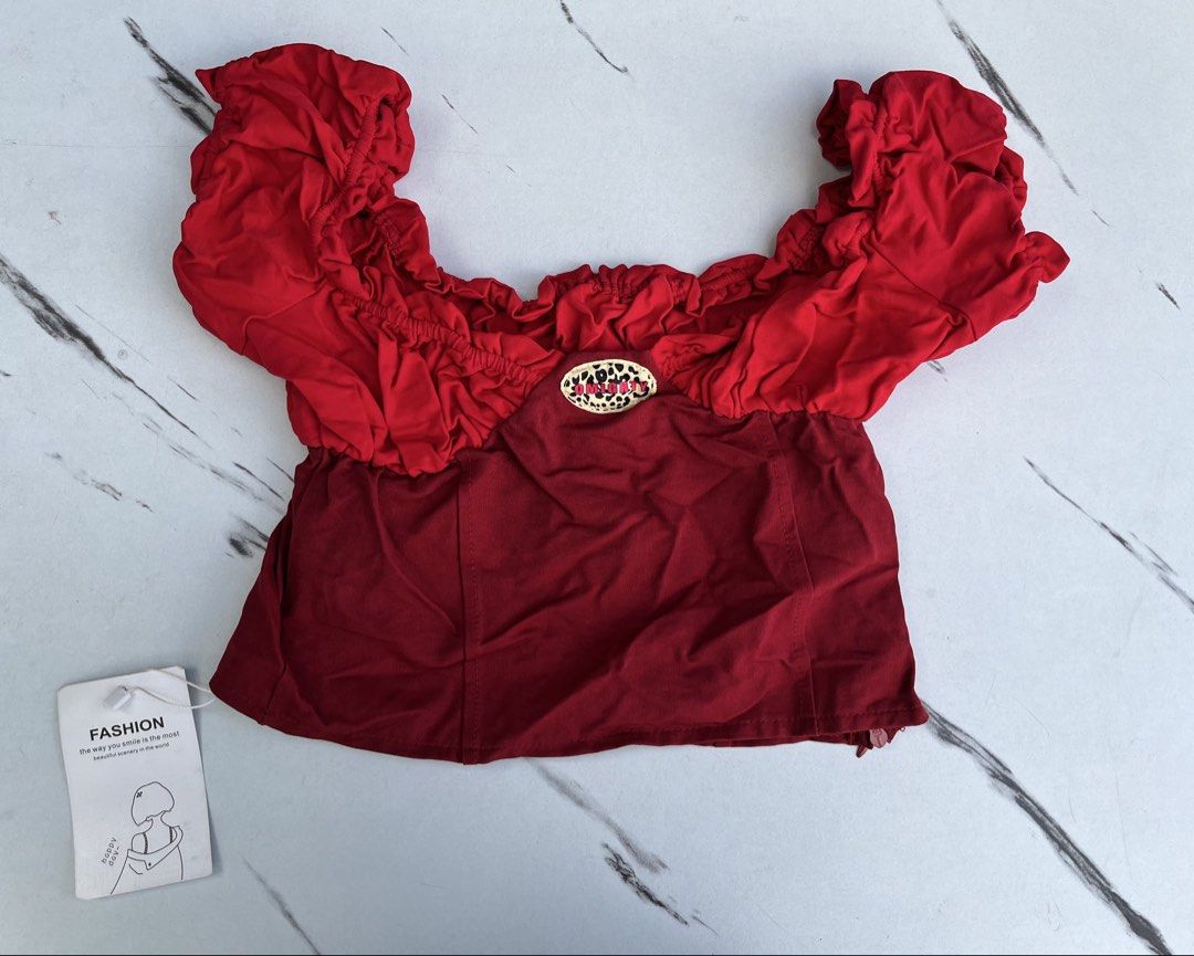 Red Off-Shoulder Crop Top with Ruffle Details (Category: Blouses) located in General Mariano Alvarez. Submitted by kascade (Listing ID 1470438319, Image 2). Description: - Condition: Brand new with tags (unworn) - Style: Off-shoulder crop top with bright red contrast top section - Details: Short ruffled sleeves, smocked neckline - Construction: Deep red structured bodice with side zipper closure - Size: XXS-XS 💵 Payment: GCash/MariBank 📦 Shippi
