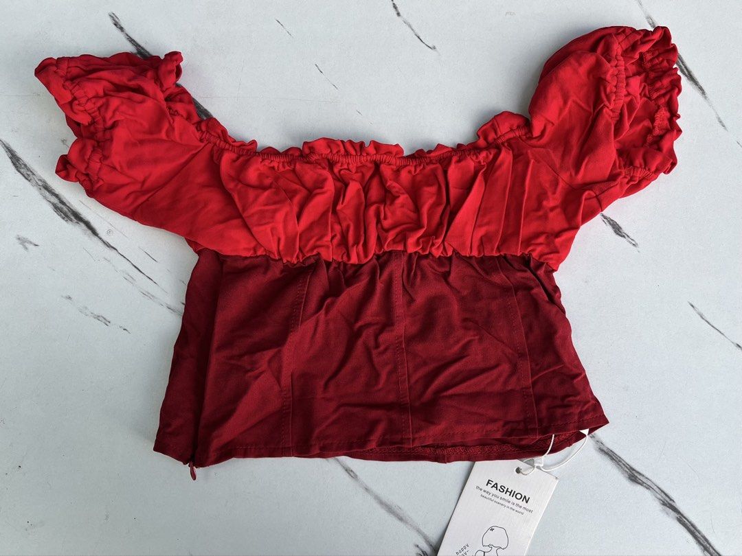 Red Off-Shoulder Crop Top with Ruffle Details (Category: Blouses) located in General Mariano Alvarez. Submitted by kascade (Listing ID 1470438319, Image 3). Description: - Condition: Brand new with tags (unworn) - Style: Off-shoulder crop top with bright red contrast top section - Details: Short ruffled sleeves, smocked neckline - Construction: Deep red structured bodice with side zipper closure - Size: XXS-XS 💵 Payment: GCash/MariBank 📦 Shippi