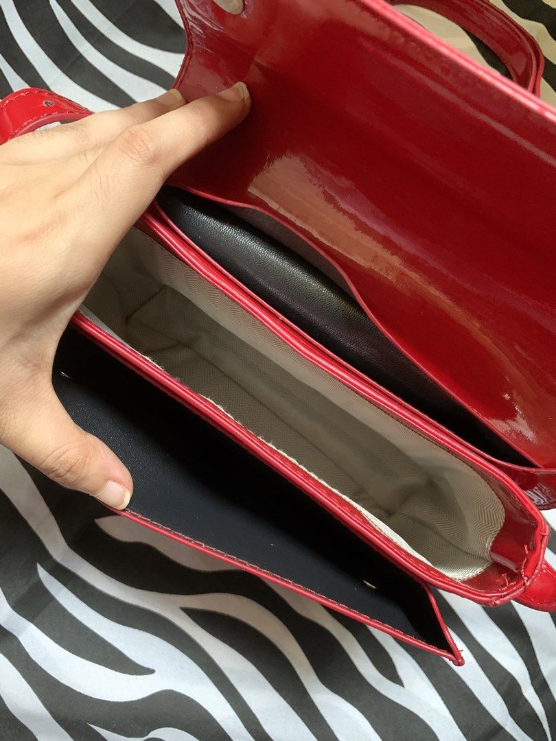 Red patent leather crossbody bag with adjustable strap (Category: Cross-body Bags) located in Manila. Submitted by usagichan_rabbit (Listing ID 1470364080, Image 2). Description: - Color & Material: Bright red patent leather with a shiny finish - Design: Classic flap front with secure snap closure - Strap: Long adjustable shoulder strap - Interior: Two main compartments with light patterned lining and a divider slot - Size: Standard medium size, 