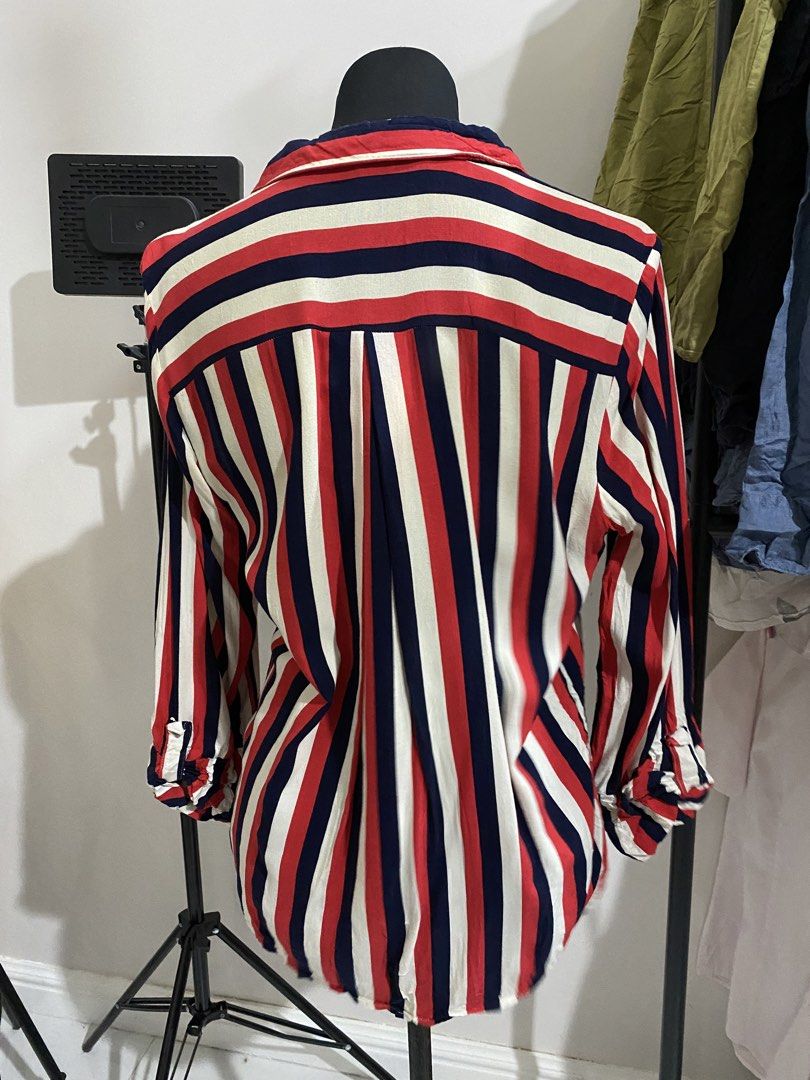Red, White and Navy Striped Button-Down Shirt (Category: Blouses) located in Manila. Submitted by mpt99876 (Listing ID 1470496460, Image 3). Description: - Bold red, white, and navy blue vertical stripe design - Classic button-down front with a pointed collar - Contrast horizontal stripe chest pocket on the left - Long sleeves with buttoned cuffs - Pleated back detail for extra movement and a relaxed fit - Lightweight, versatile fabric great for 