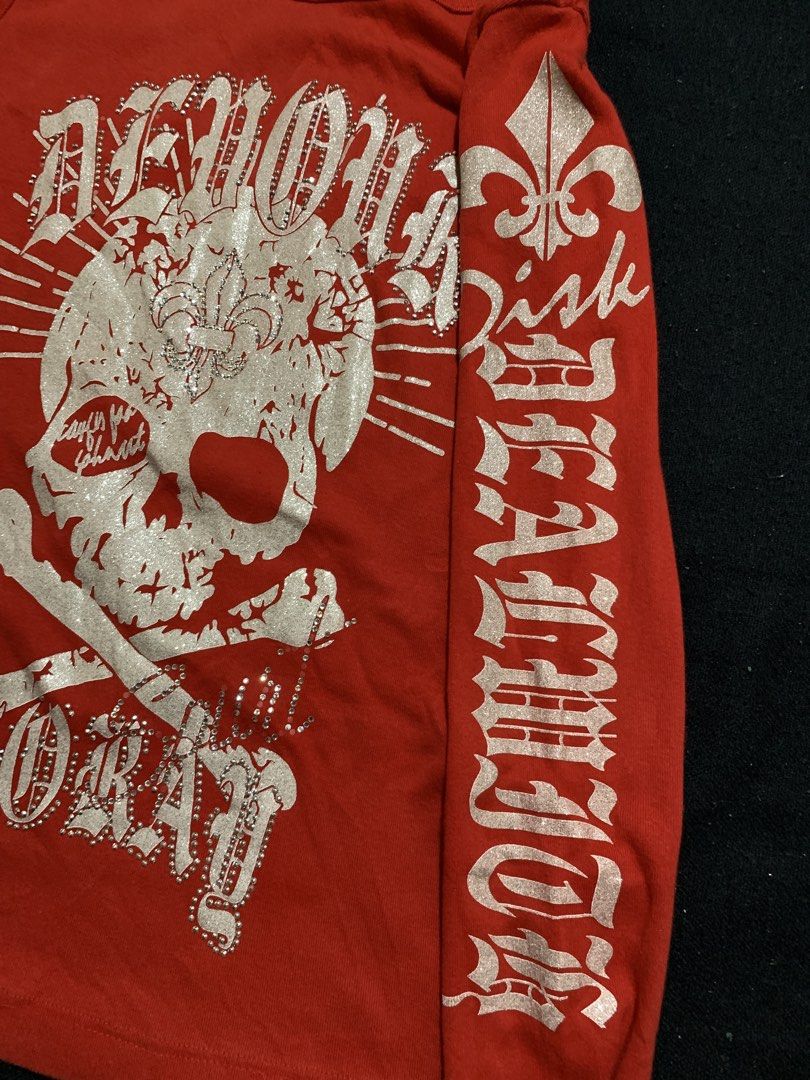 Red Y2K Rhinestone Skull Long Sleeve Top (Category: Longsleeves) located in Cagayan de Oro. Submitted by chabermz (Listing ID 1470532296, Image 3). Description: Bright red long sleeve top with heavy rhinestone embellishments. Huge skull and crossbones graphic on the front with silver glitter print. Gothic font text running down the sleeves. Lace-up grommet detail with rhinestones across the upper back neckline. Crew neck style with small gold stu
