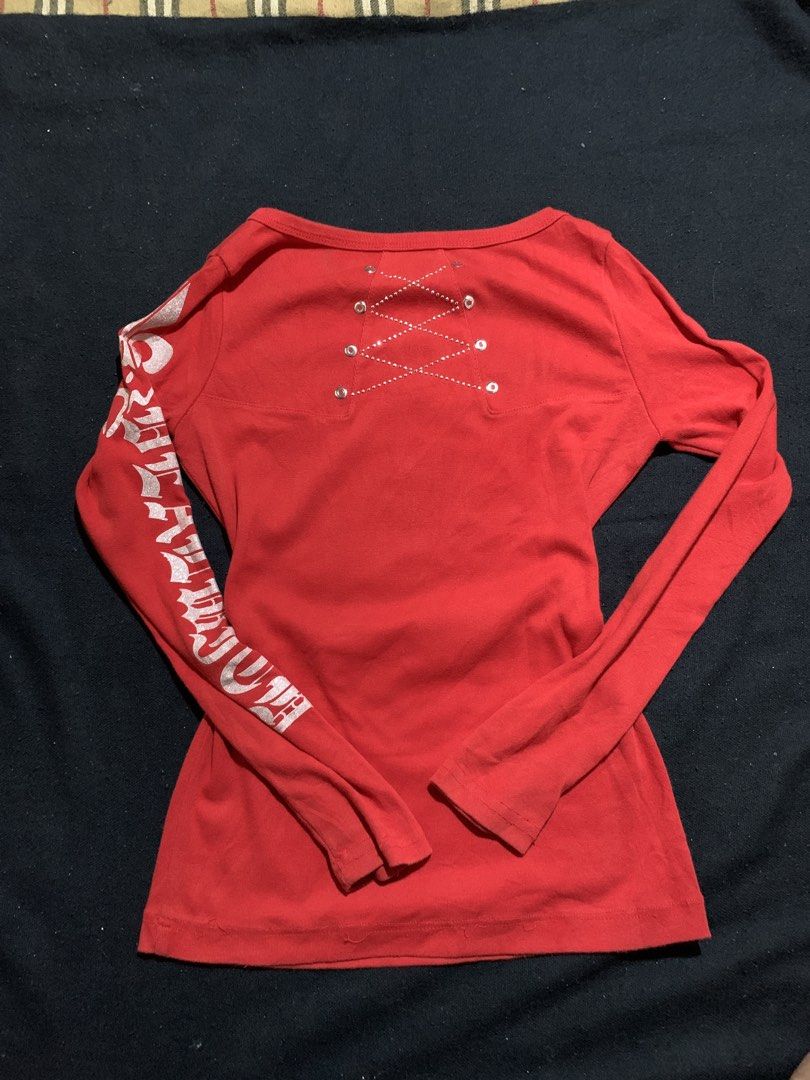 Red Y2K Rhinestone Skull Long Sleeve Top (Category: Longsleeves) located in Cagayan de Oro. Submitted by chabermz (Listing ID 1470532296, Image 2). Description: Bright red long sleeve top with heavy rhinestone embellishments. Huge skull and crossbones graphic on the front with silver glitter print. Gothic font text running down the sleeves. Lace-up grommet detail with rhinestones across the upper back neckline. Crew neck style with small gold stu