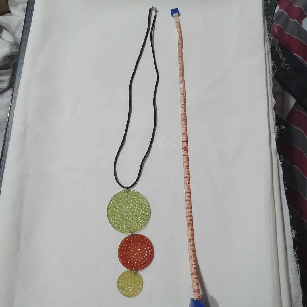 Resin Statement Pendant Necklaces (Category: Necklaces) located in Caloocan City. Submitted by mma_222 (Listing ID 1470398902, Image 3). Description: - Style: Set of 2 statement necklaces on black cords - Design 1: Three textured hanging circles in green, red, and yellow - Design 2: Oval pendant featuring white floral motifs and round dots on a translucent base - Material: Chunky yet lightweight resin - Perfect for: Elevating your everyday casual