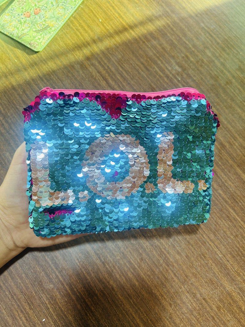 Reversible Sequin LOL Pouch Pink and Teal (Category: Purses & Pouches) located in Manila. Submitted by starbalesukandjapansurplus (Listing ID 1470555717, Image 1). Description: - Fun reversible sequin pouch with LOL lettering - Dual-color design: flip from teal to hot pink sequins - Secure zip top closure with bright pink inner lining - Versatile use for stationery, makeup, or small accessories.