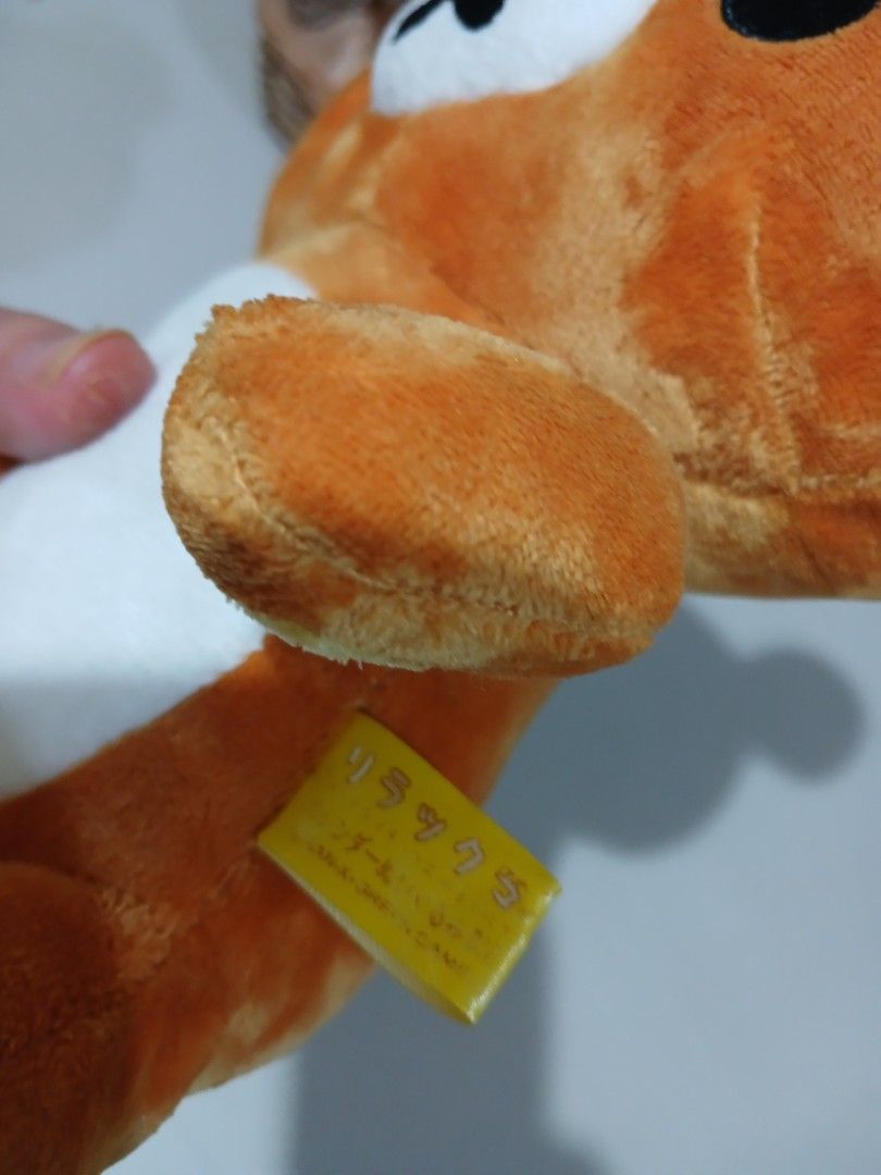 Rilakkuma Bear Plush Toy with Zipper (Category: Plushies & Soft Toys) located in Antipolo. Submitted by u_buy (Listing ID 1470522262, Image 3). Description: Rilakkuma plush toy with white tummy and yellow inner ears. Zipper detail running down the back. Yellow tag attached to the side near the arm. Soft fabric material, about 20 cm in length. Clean surface, no tears or loose threads found..