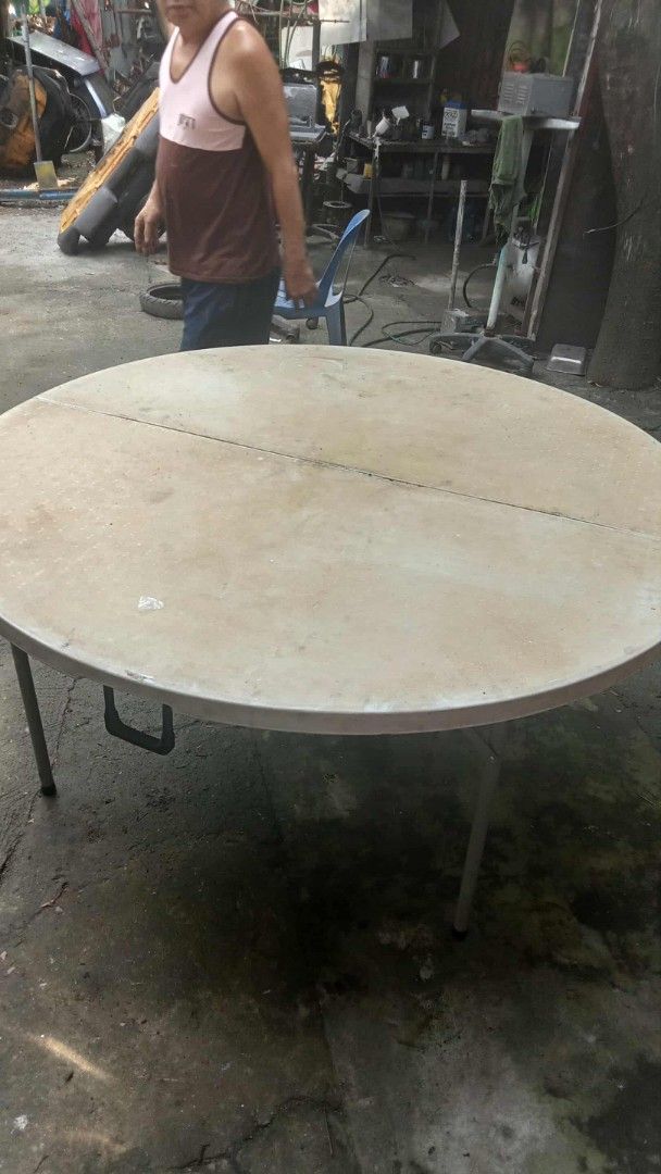 Round Foldable Plastic Event Table with Metal Frame (Category: Tables & Sets) located in Manila. Submitted by wisegem-231b (Listing ID 1470403674, Image 1). Description: - Large round folding table with a durable white plastic top and honeycombed underside structure - Secure grey metal folding legs that lock firmly into place - Conveniently folds in half with a built-in carrying handle for effortless transport and compact storage - Ideal for part