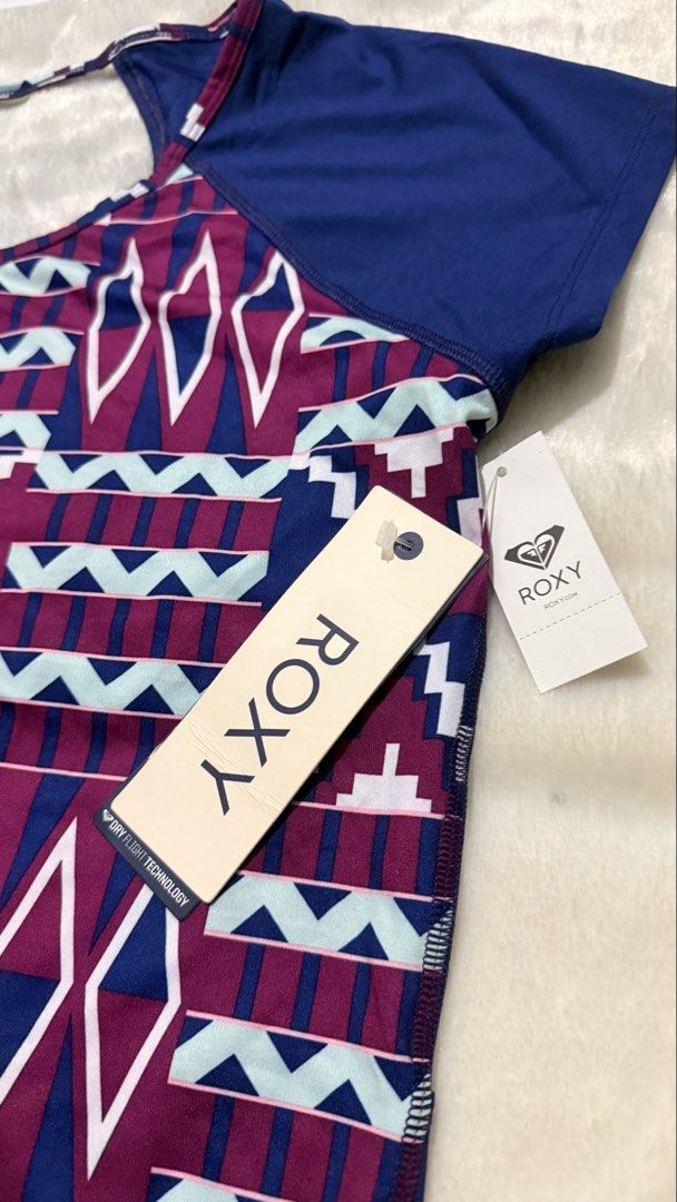 Roxy Aztec Pattern Short Sleeve T-Shirt Drifit (Category: Shirts) located in Makati City. Submitted by Everythingnice2022 (Listing ID 1470528057, Image 2). Description: 38-42 bust 34-36 waist - Brand: Roxy - Condition: Brand new with original paper retail tags - Color: Navy blue with colorful geometric Aztec pattern on front - Size: Number 1 - Material/Tech: Dry Flight technology fabric - Design: Blue cap sleeves, short sleeve - Origin: Made in I