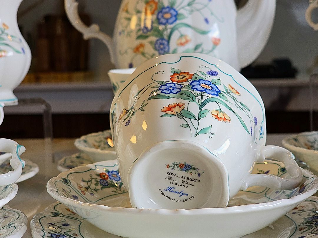 Royal Albert Hamlyn Coffee Set (Category: Coffee & Tea Tableware) located in Compostela. Submitted by curatedcabinetcebu (Listing ID 1470547886, Image 2). Description: - Authentic Royal Albert bone china tea set in Hamlynpattern - Complete 6-person service including large coffee pot, creamer, and lidded sugar bowl - Includes 6 teacups, matching saucers and cake plates - Elegant white background adorned with a vibrant blue and orange floral motif 