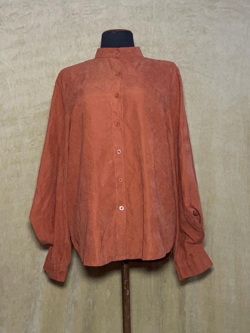 Rust Orange Long Sleeve Button Up Blouse (Category: Longsleeves) located in Batangas. Submitted by mkjgb (Listing ID 1470469729, Image 1). Description: - Color: Rust orange - Material: Soft faux suede fabric - Design: Mandarin collar with a full button front closure - Sleeves: Dramatic balloon sleeves with fitted button cuffs - Fit: Relaxed body fit with a curved hemline - Condition: Excellent / Like new - Perfect for: Smart casual, office wear, 