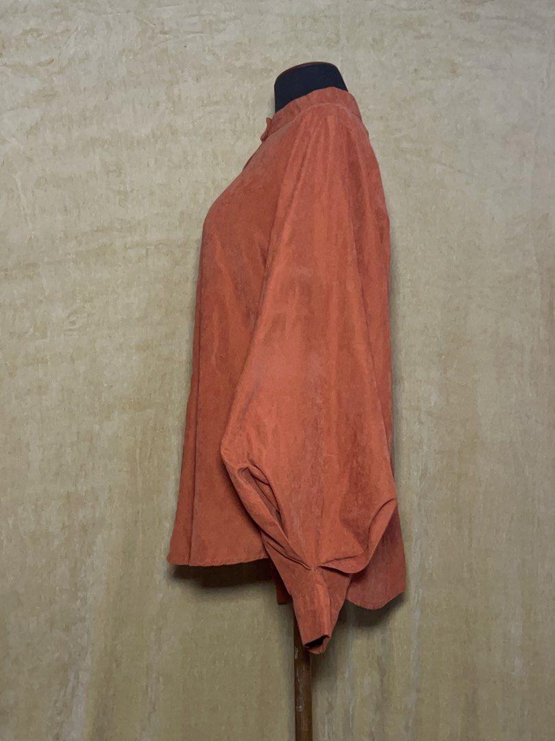 Rust Orange Long Sleeve Button Up Blouse (Category: Longsleeves) located in Batangas. Submitted by mkjgb (Listing ID 1470469729, Image 2). Description: - Color: Rust orange - Material: Soft faux suede fabric - Design: Mandarin collar with a full button front closure - Sleeves: Dramatic balloon sleeves with fitted button cuffs - Fit: Relaxed body fit with a curved hemline - Condition: Excellent / Like new - Perfect for: Smart casual, office wear, 