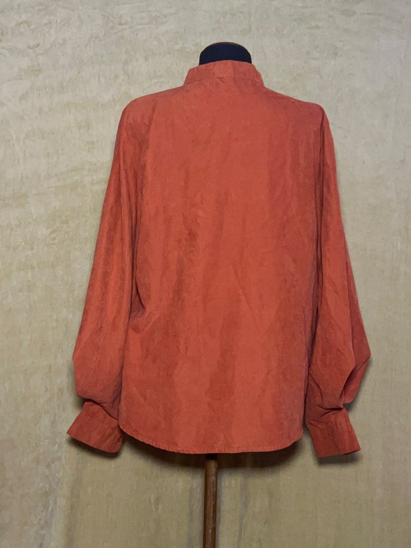 Rust Orange Long Sleeve Button Up Blouse (Category: Longsleeves) located in Batangas. Submitted by mkjgb (Listing ID 1470469729, Image 3). Description: - Color: Rust orange - Material: Soft faux suede fabric - Design: Mandarin collar with a full button front closure - Sleeves: Dramatic balloon sleeves with fitted button cuffs - Fit: Relaxed body fit with a curved hemline - Condition: Excellent / Like new - Perfect for: Smart casual, office wear, 
