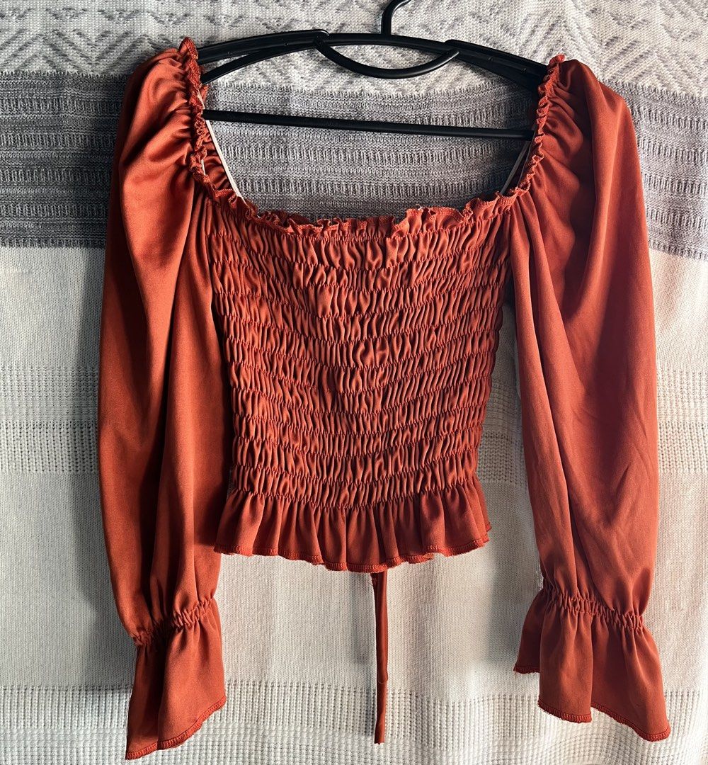 Rust Orange Smocked Crop Top with Puff Sleeves (Category: Blouses) located in General Mariano Alvarez. Submitted by kascade (Listing ID 1470465363, Image 2). Description: - Color: Rust orange - Style: Crop top with long puff sleeves, ruched body, square neckline, and ruffle hem - Details: Front drawstring tie - Fabric: Stretchy and lightweight 💵 Payment: GCash/MariBank 📦 Shipping: Lalamove 📍Location: GMA, Cavite.