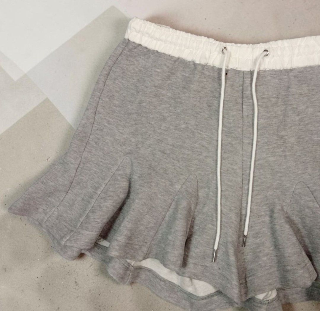 Sacai - Pleated - Sway Sweat - Short (Category: Shorts) located in Manila. Submitted by grmnts_frmthe_slmz (Listing ID 1470393981, Image 2). Description: Sacai sweatshorts in grey with white elasticated waistband. Drawstring closure with metal aglets. Unique flared hem construction giving a skirt-like silhouette. Wstlne 14.5 inches Crtch 11.5 inches Insm 4 inches L 16 inches LgOpng 20 inches Origin: Japan Materials: Cotton 100% Authentic Color Ra