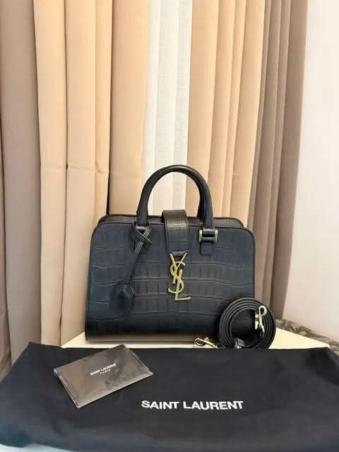 Saint Laurent Black Croc Embossed Leather Handbag (Category: Luxury Bags & Wallets) located in Taguig. Submitted by Myclosetdeclutter (Listing ID 1470356599, Image 1). Description: - Brand: Yves Saint Laurent (YSL) - Material: Black leather with crocodile texture - Hardware: Elegant gold-tone accents featuring the classic YSL monogram - Versatility: Includes double top handles and a detachable strap - Closure: Secure top zip closure - Inclusions: