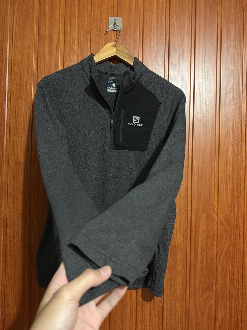 Salomon Dark Grey Quarter-Zip Pullover with Chest Pocket (Category: Coats, Jackets and Outerwear) located in Manila. Submitted by tlfph (Listing ID 1470474522, Image 3). Description: - Brand: Salomon - Color: Dark grey with contrast black zippered chest pocket - Details: White Salomon logo branding, high collar, long sleeves - Material: Textured fleece-like fabric - Ideal for: Running, hiking, or casual everyday wear - Condition: Clean interior c