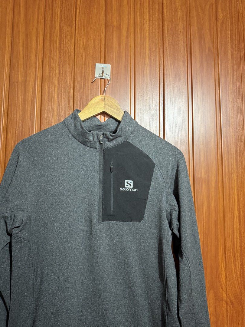 Salomon Dark Grey Quarter-Zip Pullover with Chest Pocket (Category: Coats, Jackets and Outerwear) located in Manila. Submitted by tlfph (Listing ID 1470474522, Image 2). Description: - Brand: Salomon - Color: Dark grey with contrast black zippered chest pocket - Details: White Salomon logo branding, high collar, long sleeves - Material: Textured fleece-like fabric - Ideal for: Running, hiking, or casual everyday wear - Condition: Clean interior c