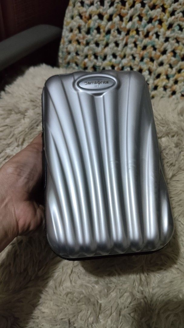 Samsonite 1910 Hard Shell Zippered Travel Pouch (Category: Belt bags, Clutches and Pouches) located in Cebu City. Submitted by lumaynojes00490 (Listing ID 1470497799, Image 2). Description: - Brand: Samsonite 1910 - Color: Sleek silver - Material: Durable hard shell with a structured ridged exterior for extra protection - Closure: Secure all-around zipper - Size: Compact and travel-friendly, fits easily inside larger bags or luggage.