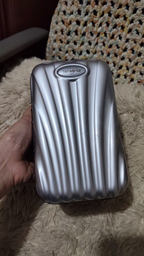 Samsonite 1910 Hard Shell Zippered Travel Pouch (Category: Belt bags, Clutches and Pouches) located in Cebu City. Submitted by lumaynojes00490 (Listing ID 1470497799, Image 1). Description: - Brand: Samsonite 1910 - Color: Sleek silver - Material: Durable hard shell with a structured ridged exterior for extra protection - Closure: Secure all-around zipper - Size: Compact and travel-friendly, fits easily inside larger bags or luggage.