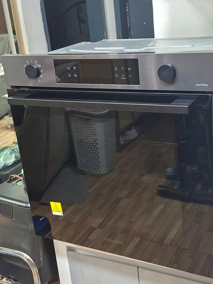 Samsung SmartThings Built-In Oven (Category: Ovens & Toasters) located in Taguig. Submitted by gongolly2007 (Listing ID 1470494669, Image 1). Description: - Brand: Samsung Built-in Oven - Design: Sleek stainless steel finish with black glass door - Controls: Rotary dial control knob and digital touch control panel - Display: LED display with timer and temperature settings - Features: Smart connectivity features and multi-mode cooking options - Co