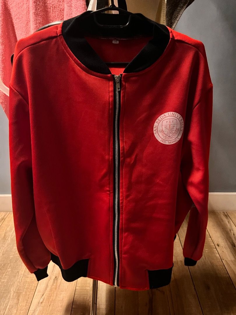 San Beda University Red and Black Bomber Jacket (Category: Coats, Jackets and Outerwear) located in Pasig City. Submitted by vastpenguin.671612 (Listing ID 1470452446, Image 1). Description: - Authentic San Beda University bomber jacket in striking red - Features black ribbed collar, cuffs, and hem for a snug fit - Full front zip closure with a durable silver zipper - University seal printed on the left chest - Bold San Beda University text print