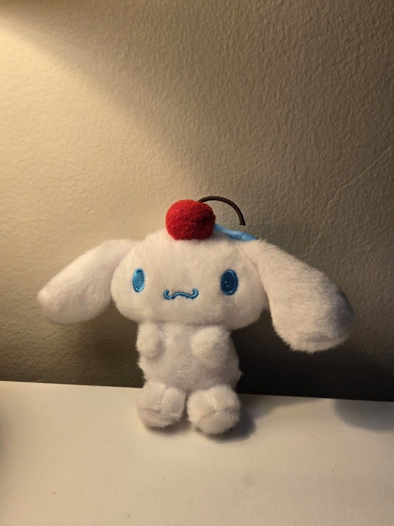 Sanrio Cinnamoroll Cherry Plush Keychain (Category: Plushies & Soft Toys) located in Bulacan. Submitted by matchiii (Listing ID 1470508198, Image 1). Description: - Adorable White Cinnamoroll plush keychain - Features cute blue embroidered eyes and face details - Soft and fuzzy material for a huggable feel - Cute red cherry accent on a brown stem near the ear - Equipped with a light blue plastic snap hook for easy hanging on bags or keys.