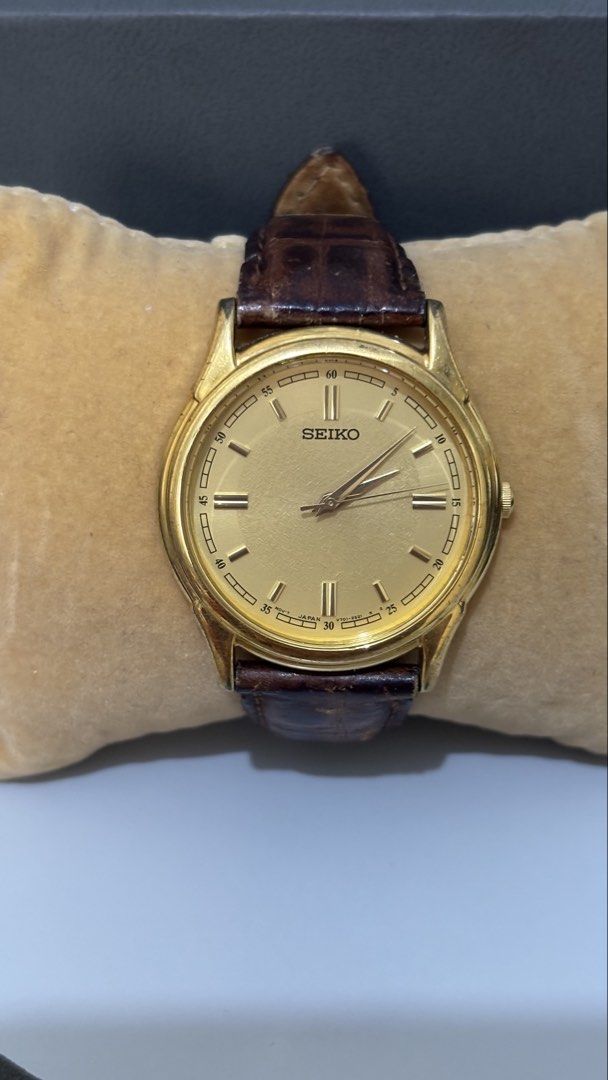 Seiko V701-1920 Gold Dial Leather Strap Watch (Category: Women's Watches) located in Caloocan City. Submitted by thrift_genieee (Listing ID 1470403992, Image 1). Description: - Brand: Seiko - Movement: Quartz - Dial: Gold textured finish - Case: Classic round, gold-tone with stainless steel back (V701-1920) - Strap: Dark brown leather with signed Seiko buckle - Condition: Visible wear on the leather strap and minor scuffs on the case No meetups ❌