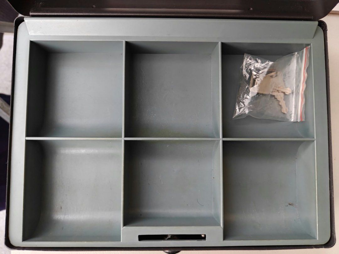 SentrySafe Black Cash Box With Removable Tray (Category: Safe) located in Antipolo. Submitted by tagsale101 (Listing ID 1470461095, Image 3). Description: - Brand: SentrySafe - Color: Classic black - Material: Sturdy metal construction - Security: Key lock on front panel (includes 2 keys in sealed bag) - Tray: Removable gray plastic tray with 6 coin and bill compartments - Storage: Extra space underneath the tray for receipt or document storage -