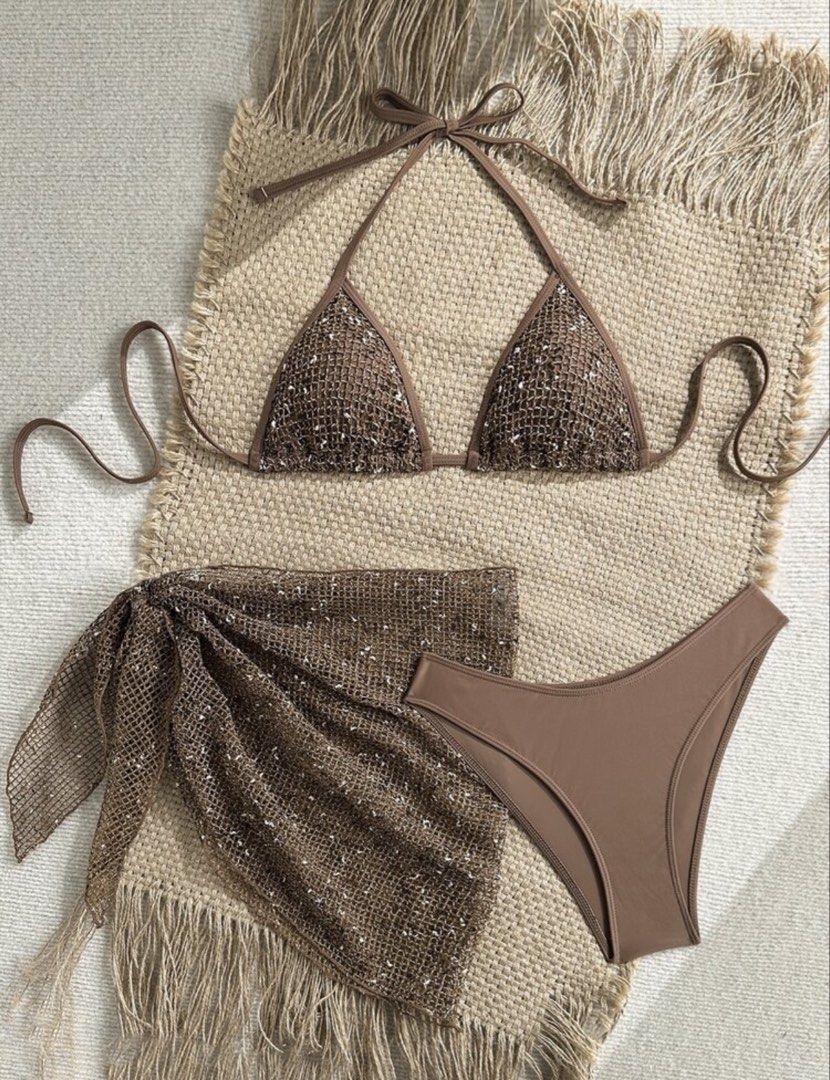 Shein Brown Bikini Set (Category: Bikinis & Swimsuits) located in Cainta. Submitted by lovecalluengg (Listing ID 1470503256, Image 2). Description: - 3-piece brown swimwear set for beach or pool days - Triangle halter bikini top accented with subtle sparkles - Matching side-tie bikini bottoms in solid brown - Sheer mesh sarong wrap with sparkly metallic threading and waist tie - Crafted from soft and comfortable stretch material.