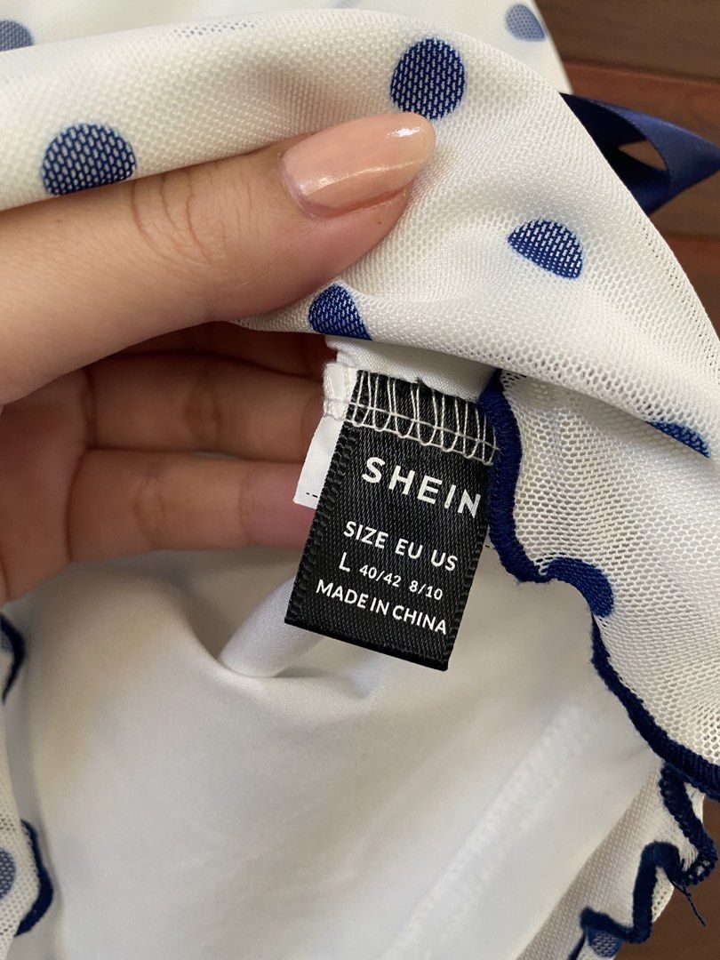 Shein White Blue Polka Dot Mesh Tank Top (Category: Sleeveless) located in Dasmarinas. Submitted by closetcleanser_ (Listing ID 1470430799, Image 3). Description: Shein white tank top with blue polka dots, size L with a solid white lining, a cute navy blue ribbon tie at the waist Please note: there is a light yellow discoloration near the right shoulder strap seam. Still a lovely piece for casual wear hehe.