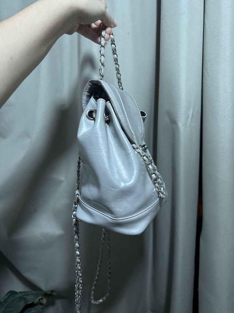 Silver Mini Backpack with Chain Straps (Category: Backpacks) located in Abucay. Submitted by fastlion.584bdf (Listing ID 1470532381, Image 2). Description: - Trendy silver mini backpack with a statement shiny finish - Features stylish silver chain straps and a convenient top handle - Secure front flap closure with a chic twist-lock clasp and drawstring cinch - Compact size ideal for daily essentials while keeping you hands-free - Clean and well-m