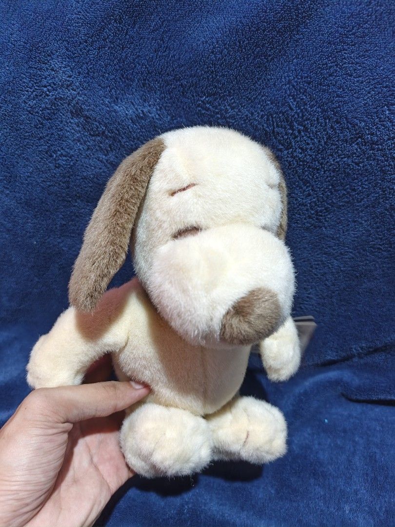 Snoopy plush toy with tag (Category: Plushies & Soft Toys) located in Manila. Submitted by kirstentoyshub (Listing ID 1470379770, Image 2). Description: - Item: Authentic Snoopy plush toy - Color/Design: Soft cream fur with brown ears and a distinctive brown spot on the back - Details: Includes original 'A Gift from Angels' tag with doghouse graphic, attached by a gold string - Condition: Clean fabric, intact stitching, and well-maintained - Orig
