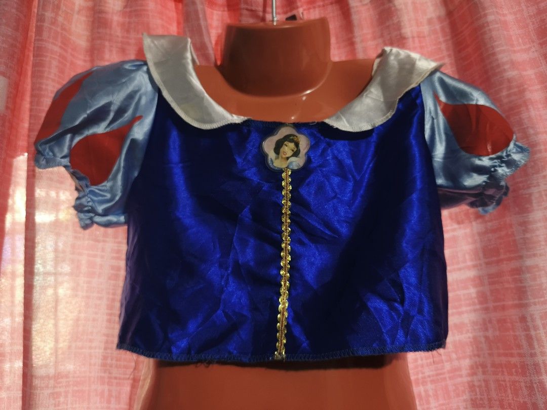 Snow White Princess Costume Top (Category: Blouses) located in Caloocan City. Submitted by mckysprelove (Listing ID 1470551708, Image 2). Description: - Royal blue fabric body with elegant gold trim down the center - Features an adorable Snow White character badge on the chest - Sheer puff sleeves accented with charming red ribbon details - Includes an attached classic white collar - Wonderful dress-up piece for little fans and parties.