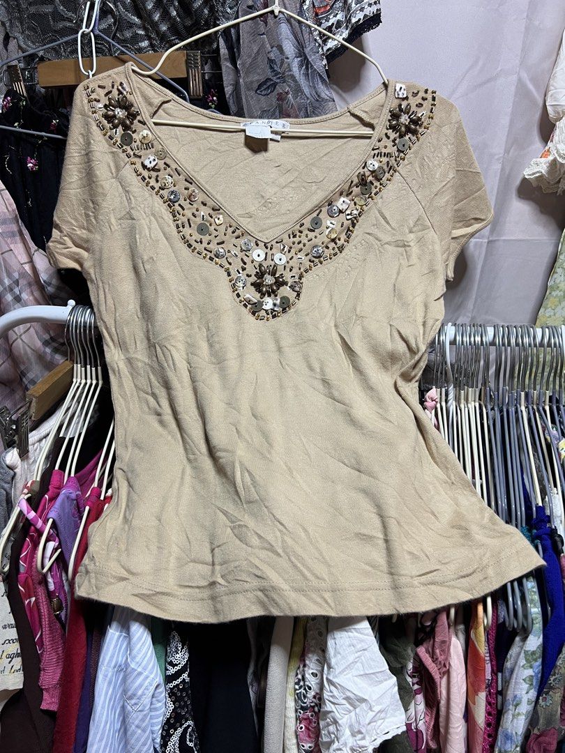 Spanner Beige V-Neck Beaded Top Size S (Category: Blouses) located in Manila. Submitted by threadly (Listing ID 1470399716, Image 1). Description: - Brand: Spanner - Size: Small (Style: S06154) - Color: Beige - Material: Lightweight cotton, relaxed fit - Details: V-neck with wooden beads, sequins, and shell accents - Style: Short sleeves, standard hem, great for casual wear with jeans or skirts.