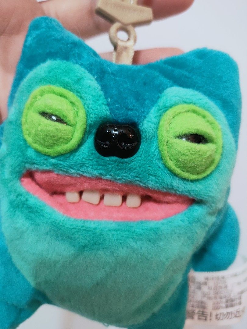 Spin Master Zuru Fuggler Greedy Grinner Plush Charm (Category: Plushies & Soft Toys) located in Antipolo. Submitted by bhabiegraciefashionlab (Listing ID 1470427810, Image 2). Description: Character: Greedy Grinner (teal/blue body with a green eye area, a wide grinning mouth, and human-like teeth). Type: 5-inch / 11–13 cm plush clip-on keyring/pendant. 🇯🇵Authentic From Japan 🔖Good as New 📸Actual Photos posted, what you see is what you'll get 