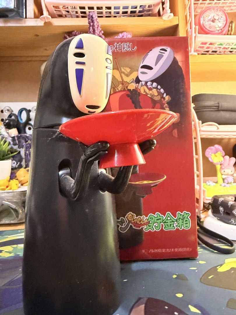 Spirited Away No Face Electronic Coin Bank (Category: Designer & Blind Box Toys) located in Baguio. Submitted by jonathanseller_buyer (Listing ID 1470512991, Image 3). Description: - Interactive feature: Place coins on the dish and No Face swallows them with sound effects and music - Battery-operated with an easy-to-use switch on the bottom - Original box included - Condition: Fully working, with minor dust in crevices.