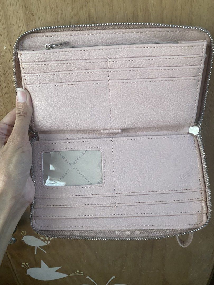 Steve Madden Pink Wristlet Wallet (Category: Wallets & Card holders) located in Bulacan. Submitted by madchen05 (Listing ID 1470357555, Image 3). Description: Steve Madden Pink Wristlet Wallet 🌟Color: Pastel pink with all-over debossed logo 🌟Includes: Matching wrist strap for easy carrying 🌟Interior: Multiple card slots, ID window, and zippered coin compartment 🌟Hardware: Silver-tone with metal logo bar 🌟Flaws: Scratches on metal logo bar & 