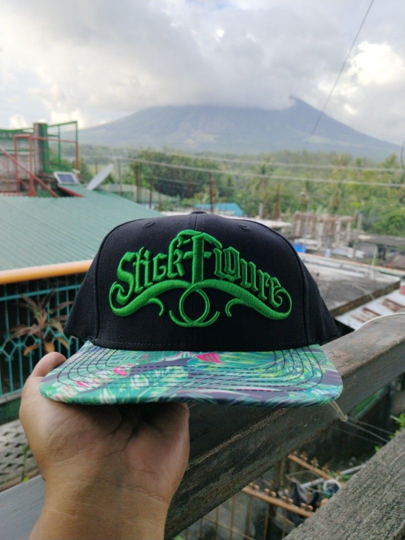 Stick Figure Snapback (Category: Caps & Hats) located in Legazpi City. Submitted by genobecollectives (Listing ID 1470429568, Image 1). Description: - Brand: Stick Figure - Color: Black with bright green embroidery - Design: Front logo, SF back logo, and tropical leaf pattern under the flat brim - Details: Interior taped seams with Stick Figure branding - Fit: Adjustable plastic snap closure - Material: 80% acrylic, 20% wool 700 plus SF.