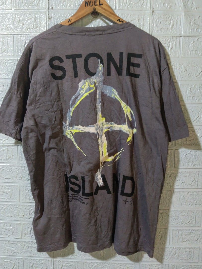 Stone Island Back Graphic T-Shirt (Category: Tshirts & Polo Shirts ) located in Davao. Submitted by noelamihan05424 (Listing ID 1470407014, Image 2). Description: - Brand: Stone Island - Color: Grey - Fit: Simple relaxed fit - Material: Comfortable cotton - Details: Small logo on chest, striped inner neck taping - Back Graphic: Large distressed compass with bold text including 'Sportswear Company Primavera Estate 21 Italy' - Condition: Grab it wh