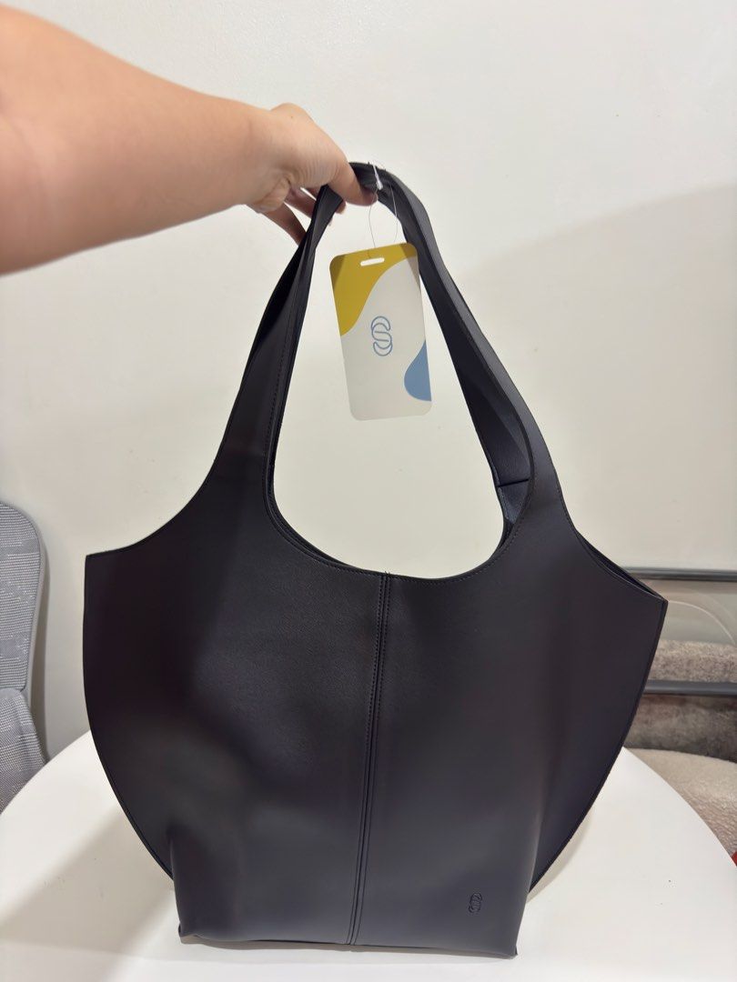 Straightforward Black Tote Bag (Category: Tote Bags) located in Quezon City. Submitted by decluttergirlie (Listing ID 1470546597, Image 1). Description: - Brand: Straightforward - Condition: Brand new with tag attached (never used, well-stored) - Color: Classic Black - Material: Smooth faux leather with stylish structured curved panels - Features: Deep main compartment, secure magnetic closure, and convenient interior slip pocket - Perfect for ev