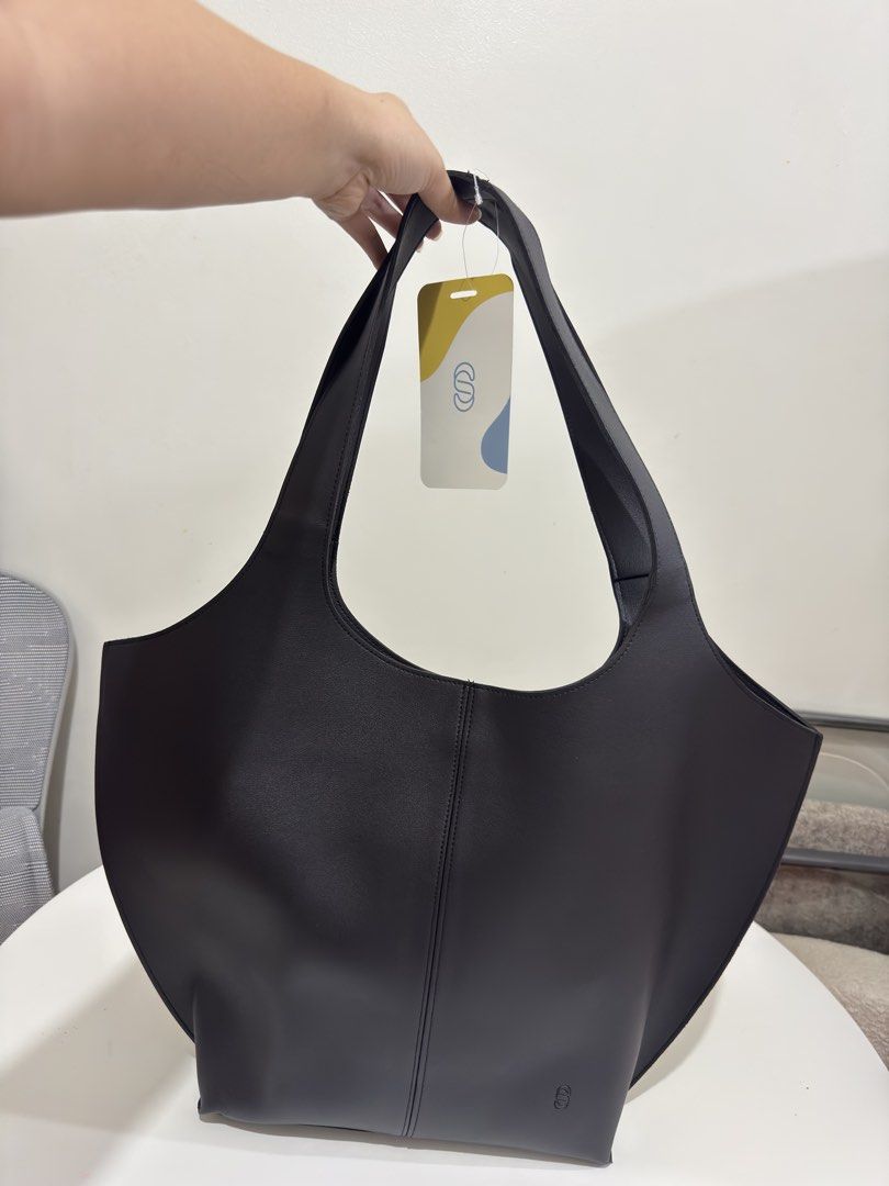Straightforward Black Tote Bag (Category: Tote Bags) located in Quezon City. Submitted by decluttergirlie (Listing ID 1470546597, Image 2). Description: - Brand: Straightforward - Condition: Brand new with tag attached (never used, well-stored) - Color: Classic Black - Material: Smooth faux leather with stylish structured curved panels - Features: Deep main compartment, secure magnetic closure, and convenient interior slip pocket - Perfect for ev