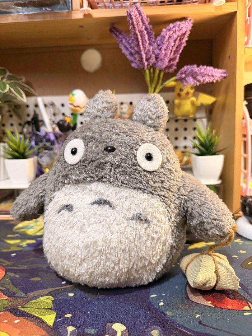 Studio Ghibli Totoro (Category: Plushies & Soft Toys) located in Baguio. Submitted by jonathanseller_buyer (Listing ID 1470514219, Image 1). Description: - Authentic Totoro plush with official tag attached - Features soft grey and white fur with classic belly markings - Holds an adorable small tied pouch - Clean and well-cared for condition - Perfect display piece for anime fans and collectors.
