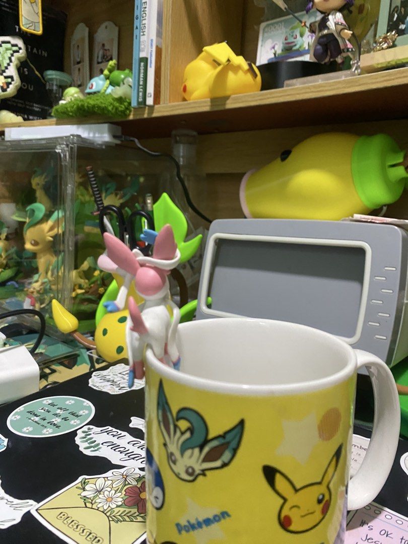 Sylveon cup edge Pokemon figure (Category: Figurines & Statues) located in Manila. Submitted by jongamba0773283 (Listing ID 1470416087, Image 2). Description: Sylveon figurine designed to hang on the rim of a mug or cup. Pastel pink and white colors with blue accents on the ears and tails. Detailed sculpt capturing the Pokémon in a playful pose. Great desk accessory or addition to any Pokémon collection..
