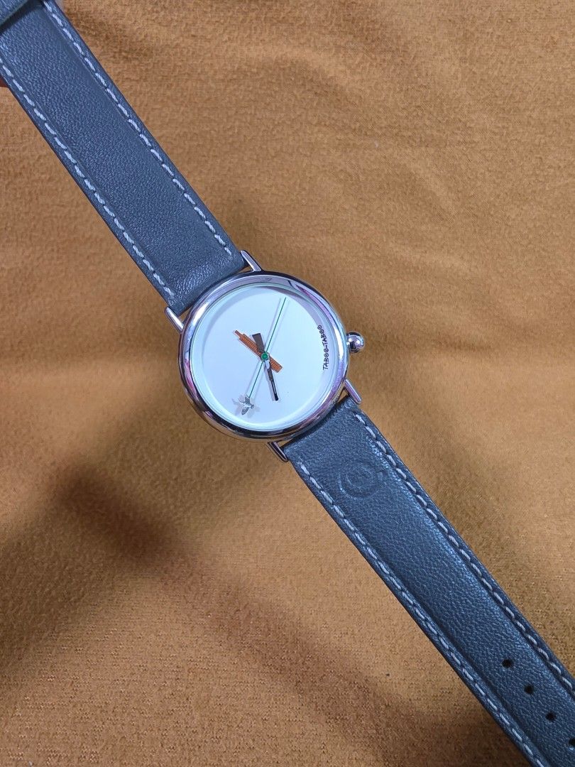 Taboo Taboo Paris J.C. Mareschal Design Quartz Watch (Category: Women's Watches) located in Rosales. Submitted by akumie30 (Listing ID 1470519463, Image 2). Description: Unique Taboo Taboo Paris quartz watch, design by J.C. Mareschal. Silver tone case with white dial featuring a whimsical hunter and duck motif on the hands. Stainless steel back, water resistant 30 meters. Dark grey leather strap with contrast stitching. Made in France. Original T
