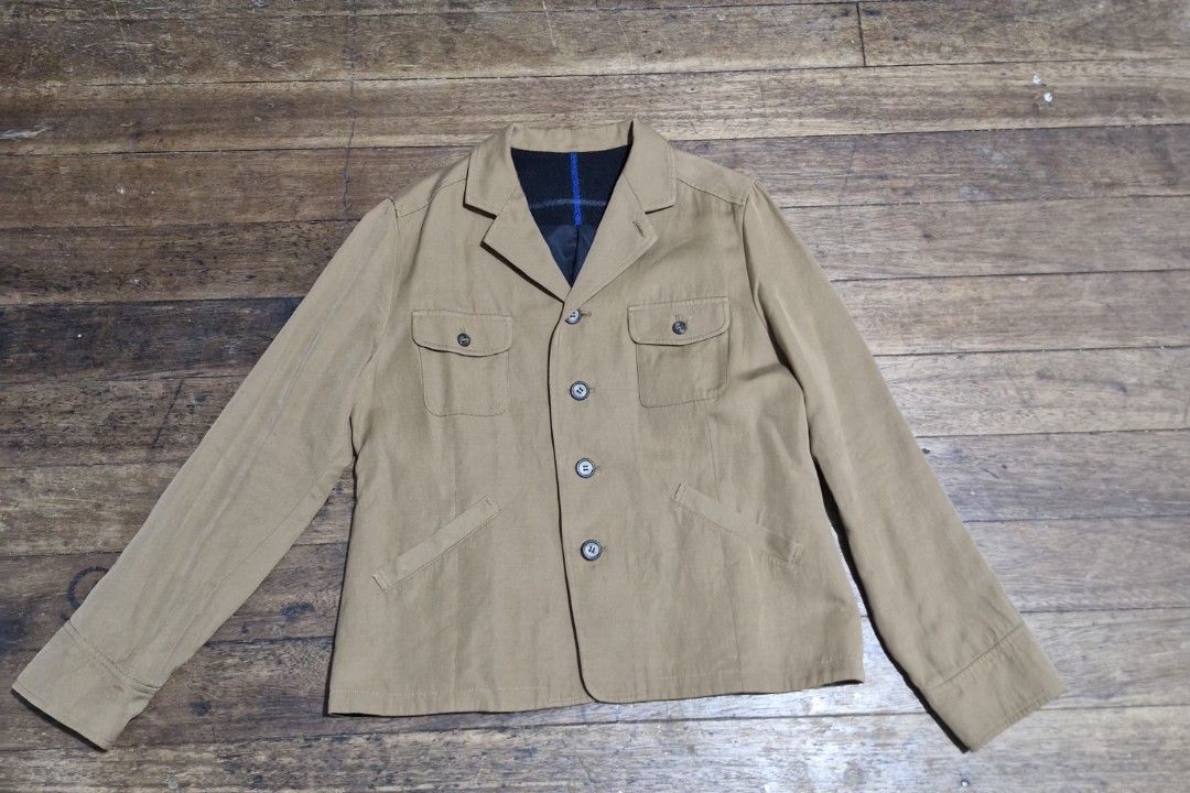 Tan Button-Up Jacket with Contrast Lining (Category: Coats, Jackets and Outerwear) located in Manila. Submitted by blackstarharpoon (Listing ID 1470524843, Image 1). Description: - Color: Versatile tan - Closure: Front button-down - Pockets: Two chest flap pockets and two lower angled pockets - Lining: Contrast dark blue and plaid lining on the inner collar - Sleeves: Long sleeves with cuffs - Fabric: Comfortable mid-weight construction - Conditi