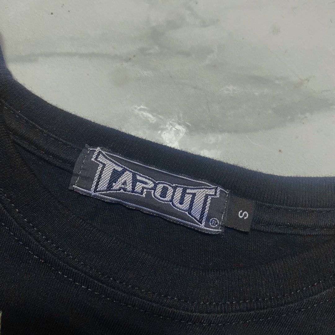 Tapout Graphic T-Shirt Size S (Category: Tshirts & Polo Shirts ) located in Camiling. Submitted by camthrift_2024 (Listing ID 1470395801, Image 3). Description: TAPOUT TEE MEDIUM 20x25 COLOR RATE: 10/10 ISSUE:❌❌❌ ₱200 PEDE VC SA JNT SHIP NOW OPEN FOR TERMS UNLI VOUCH GCASH JNT CAMILING, TARLAC📌 - Brand: Tapout - Color: Black - Size: Small (tagged at collar) - Design: Large eagle and logo graphic on front with 'BELIEVE', 'TRAN HARD', and star det
