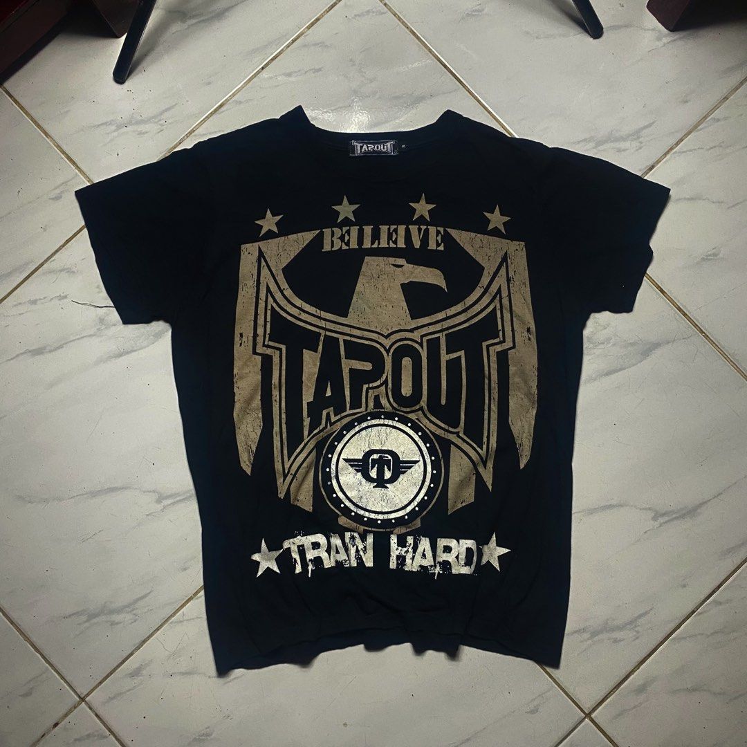 Tapout Graphic T-Shirt Size S (Category: Tshirts & Polo Shirts ) located in Camiling. Submitted by camthrift_2024 (Listing ID 1470395801, Image 2). Description: TAPOUT TEE MEDIUM 20x25 COLOR RATE: 10/10 ISSUE:❌❌❌ ₱200 PEDE VC SA JNT SHIP NOW OPEN FOR TERMS UNLI VOUCH GCASH JNT CAMILING, TARLAC📌 - Brand: Tapout - Color: Black - Size: Small (tagged at collar) - Design: Large eagle and logo graphic on front with 'BELIEVE', 'TRAN HARD', and star det